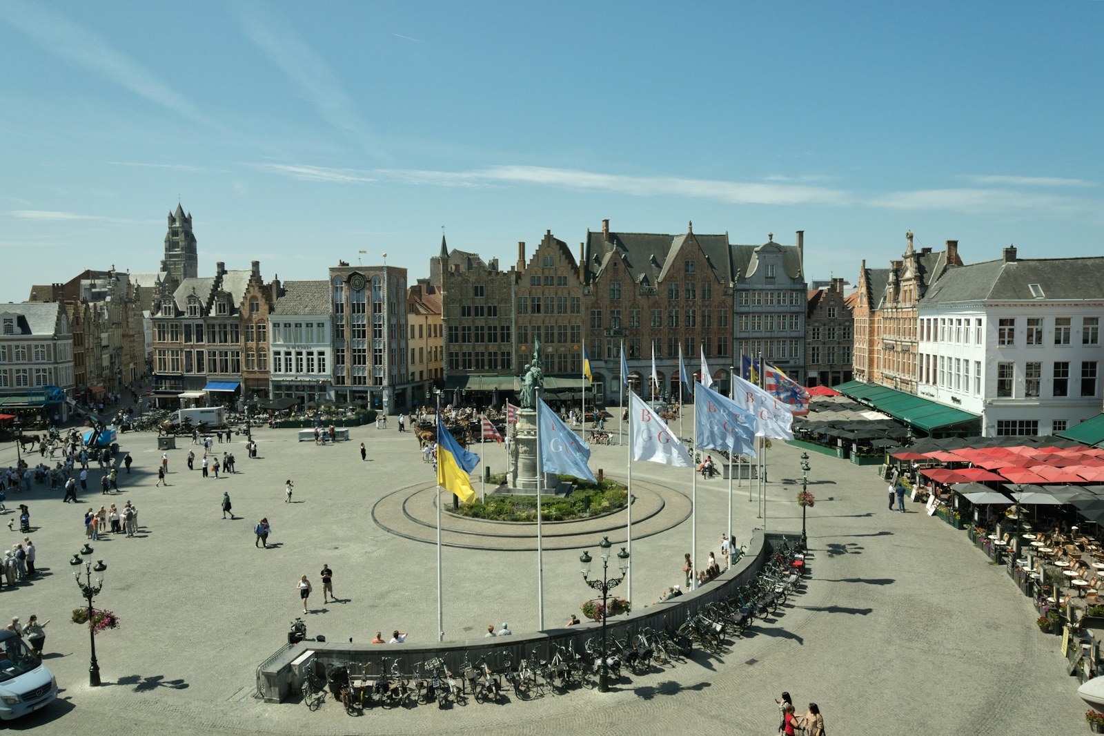 People crossing a sunlit square in Bruges